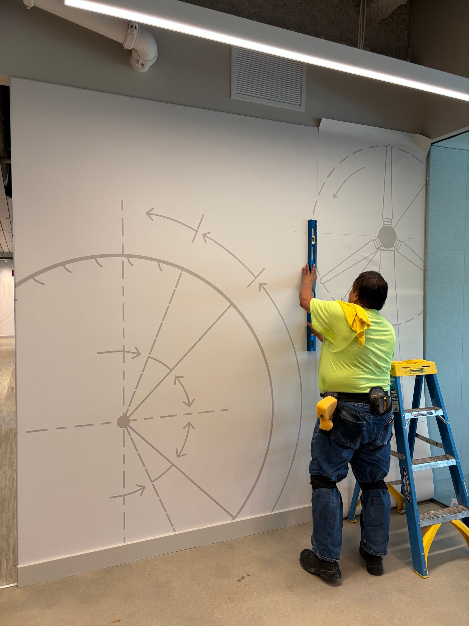 Installer aligning wall graphics with a level