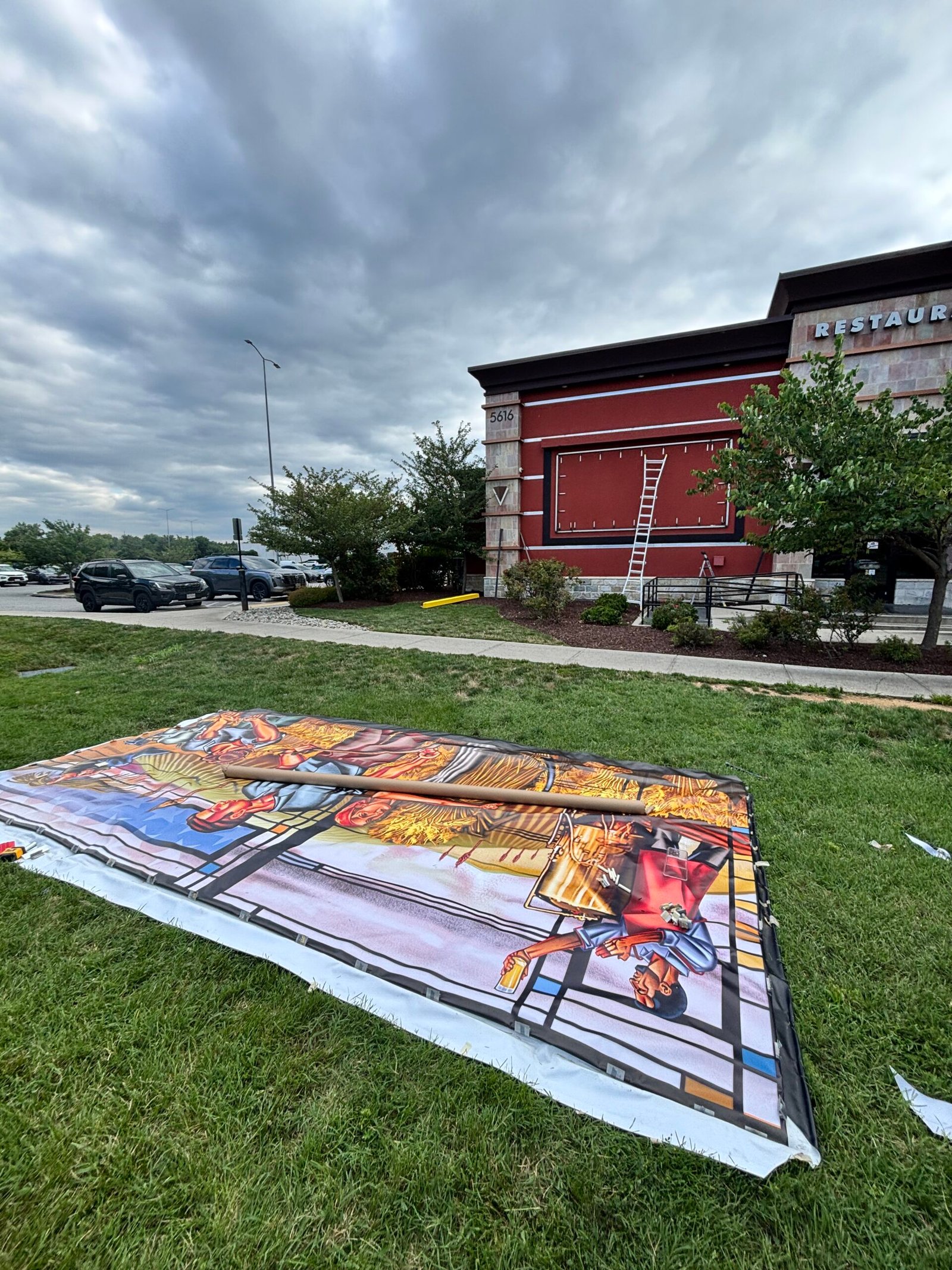 Large-format printed mural panels prepared outdoors